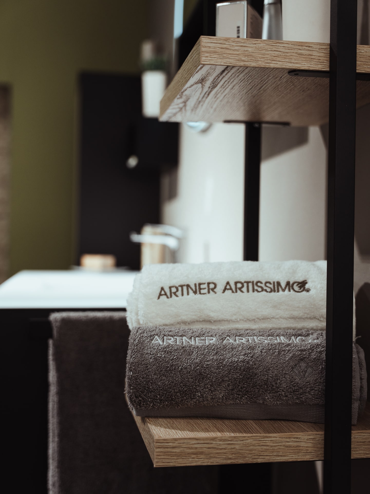 Badezimmer, Metallregal mit Holzfächer in dem zwei Handtücher liegen